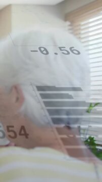 Vertical video: Senior woman using phone turning head checking finance charts overlaying scene