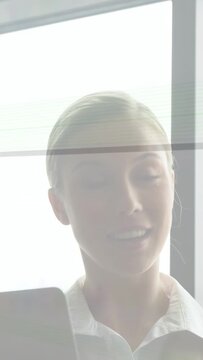 Vertical video: Businesswoman viewing tablet, looking up and reacting to animated message appearing