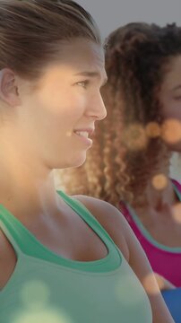 Vertical video: Lead woman turning to side as sun shifting bokeh in fitness peer watching for sport