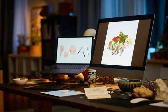 Desktop computer and laptop with digital art in modern home office