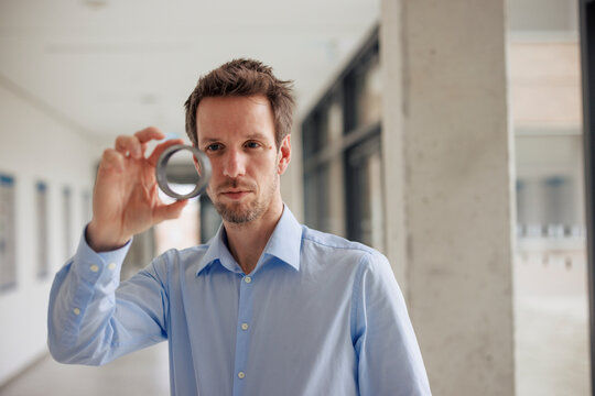 Engineer analyzing round object at workshop