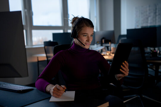 Smiling customer service representative talking on video call in office