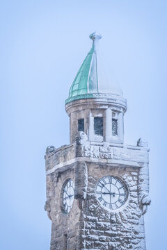 Snow covered clock tower at Landungsbrucken in Hamburg Germany