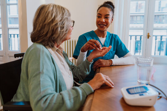 Caregiver explaining medication guidance to senior at home