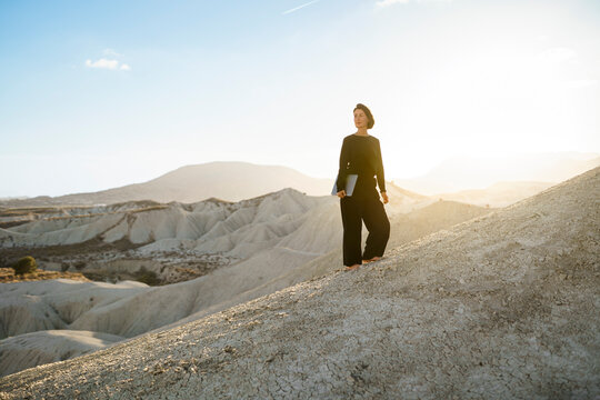 Designer holding laptop in remote desert of Murcia Spain