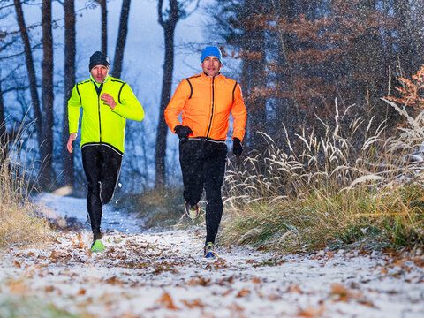 Outdoor trail running training in winter forest with snow in Germany