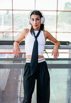 Fashion model listening to music with headphones in the city