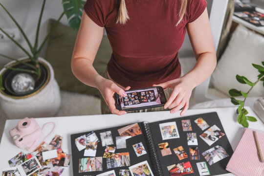 Woman photographing a handmade scrapbooking album with a smartphone