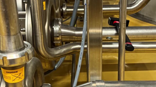Close-up of metal pipes and valves in an industrial setting, showcasing complex engineering. Suitable for manufacturing or engineering content.