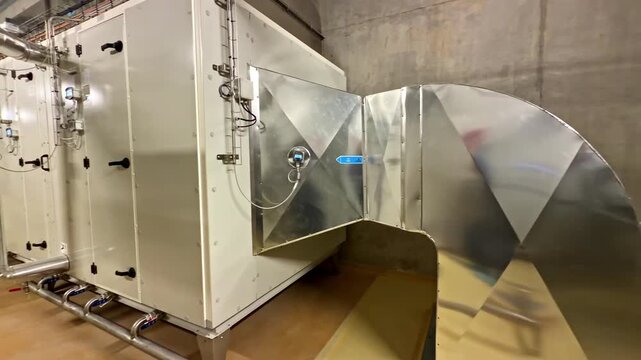 Brightly lit industrial facility showcasing stainless steel ductwork and ventilation system. Ideal for use in engineering or industrial design content.