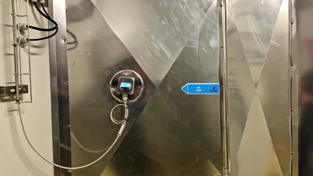 Close-up of a metal industrial ventilation system featuring a digital control panel. Useful for technology or industrial process videos.