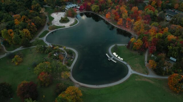 aerial shot revealing the lac aux castors in Mont Royal park during fall in Montreal city, Quebec Province, Canada