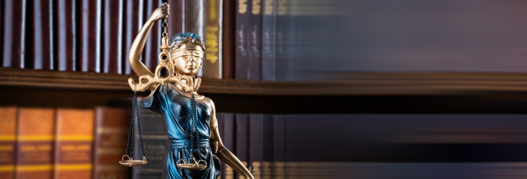 Close-up of a classical justice statue holding scales and sword, symbolizing law, fairness, balance, and the integrity of the legal system.