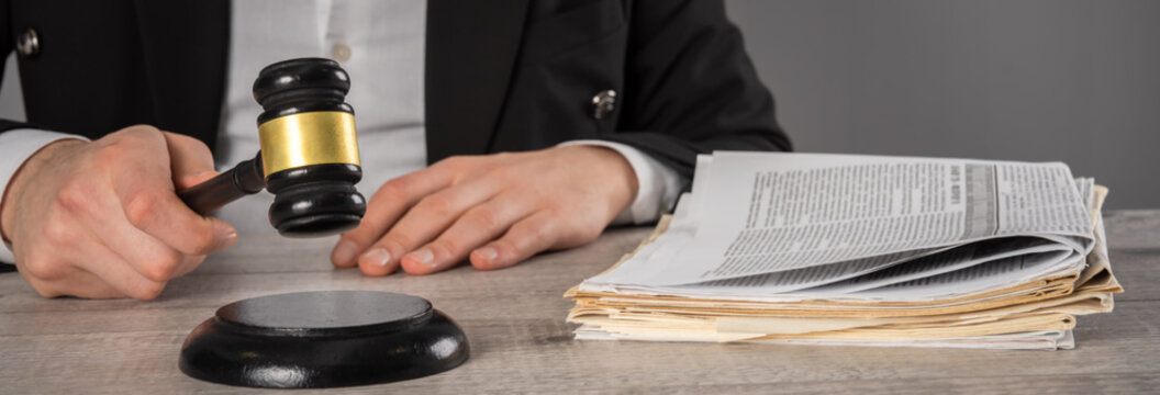 Legal documents and newspapers on desk representing court case filed against media printing company, symbolizing journalism, law, freedom of press, and legal dispute.