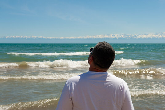 man on the beach watching blue sky