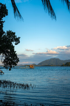 Sunset beach with boats at Bolilanga Island, Togian archipelago, Sulawesi, Indonesia