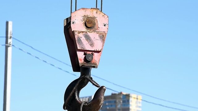 Close-up of a construction crane hook performing construction and transportation work.
