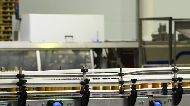 A conveyor belt with cans of mashed vegetables moving along it.