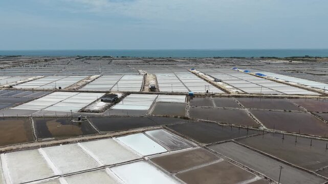 Aerial view of salt harvesting ponds over coastal India, crystal salt ponds.
