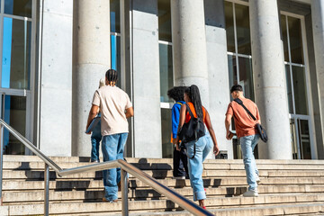 Fototapeta premium Diverse students walking up stairs on university campus
