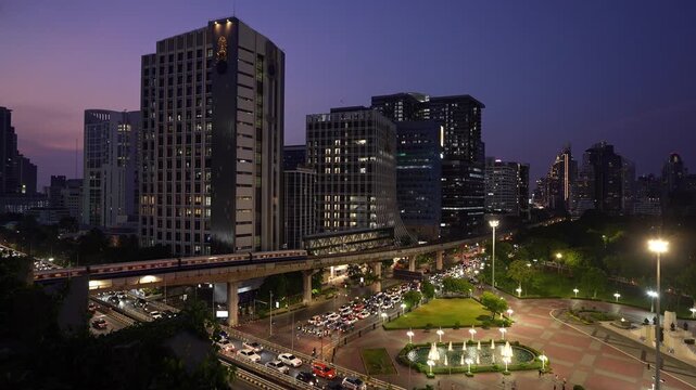 Bangkok, Thailand: Static sunset footage of a BTS train riding by the Lumphini park in downtown Bangkok by Silom business district in Thailand capital city