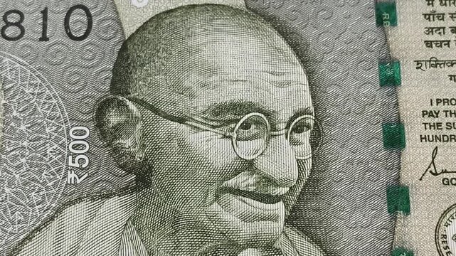 Mahatma gandhi face on rupee indian currency bank note. Extreme closeup top view. Deposit, credit, pension, devaluation, debt, loan, business, banking, forex trade, money exchange or commerce concept.
