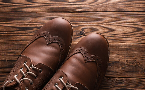 Brown Leather Men's Brogue Shoes on Wooden Floor. Top view