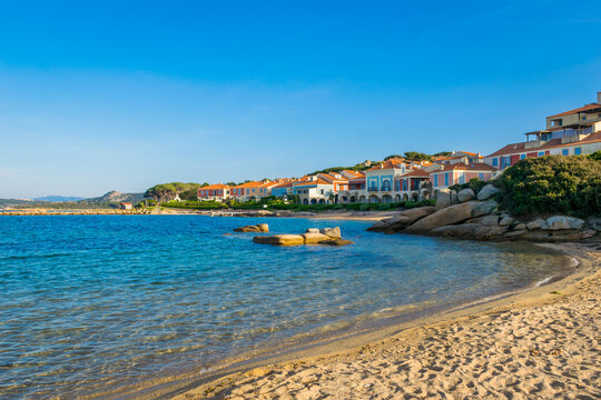 Panoramic view of colorful Porto Faro vacation houses with sandy beach during sunset, Palau, Sardinia Island, Italy