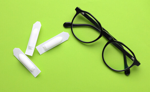 Rectal suppositories and eyeglasses on a green background