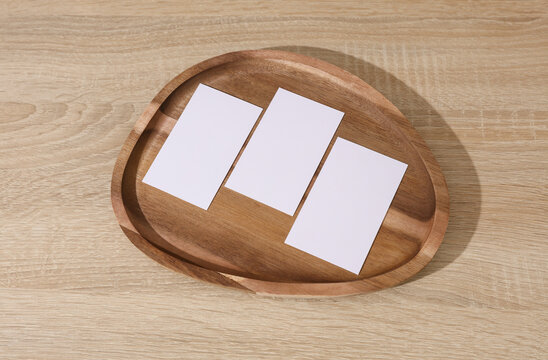 Natural wooden tray with blank white business cards on table. Corporate Identification. Business concept
