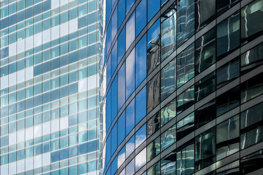 Corporate building office exterior with modern glass facade windows reflections and blue grid architecture pattern creating clean daylight background