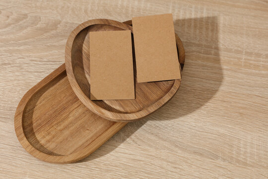 Natural wooden trays with blank craft business cards on table. Corporate Identification. Business concept