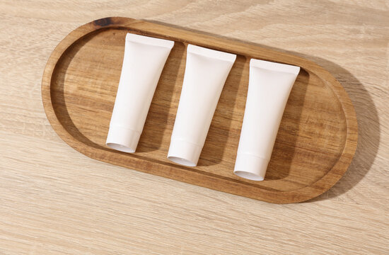 White blank crem tubes in a wooden tray. Beauty concept