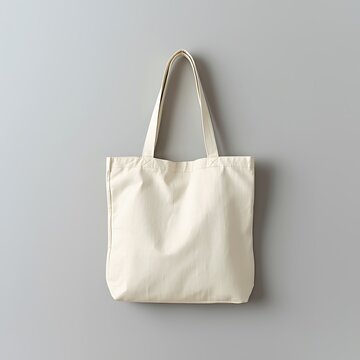 Off white canvas tote bag on a photograph, image light gray background minimalist studio shot