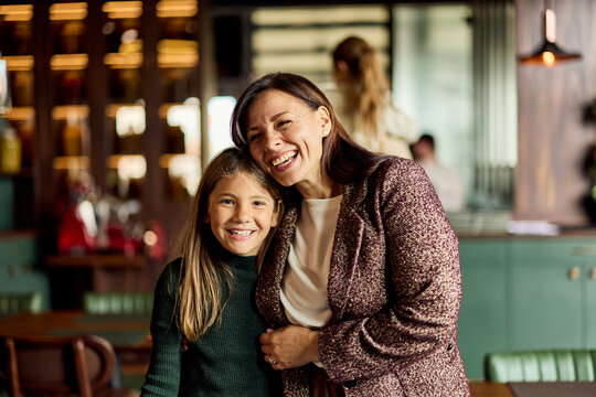 Smiling Mother and Daughter Bonding at a Cozy Cafe Restaurant &mdash; Family Portrait for Lifestyle and Marketing