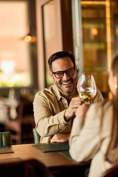 Happy Couple Toasting With Wine During Casual Date Night At A Cozy Restaurant