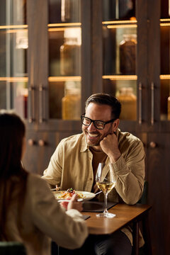 Smiling Couple Enjoying Dinner and Wine at a Cozy Restaurant During a Relaxed Date Night