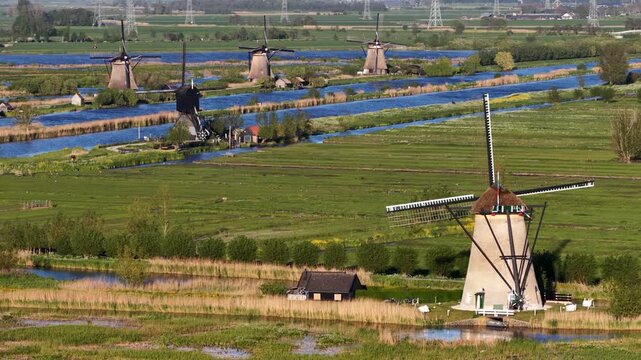 Traditional dutch windmills rotating in kinderdijk landscape