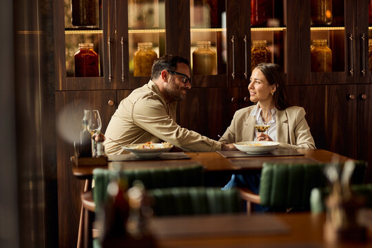 Smart-Casual Couple Sharing Wine and Dinner Conversation in Stylish Restaurant on a Relaxed Date