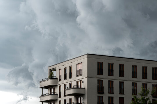Storm sky and dramatic clouds over a modern urban cityscape architecture building with windows deliver an editorial mood with background copy space