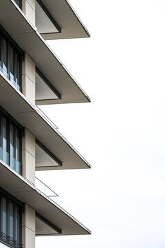 Balconies frame a modern minimal architecture building facade beneath sky with blank background space for quiet urban editorial copy placement