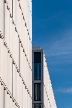 Strong lines and perspective on a modern minimal architecture building facade under blue sky provide urban copy space for editorial layout needs