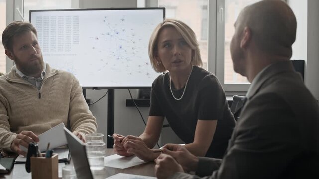 Medium shot of adult people gathering in office and communicating, discussing business plans and ideas
