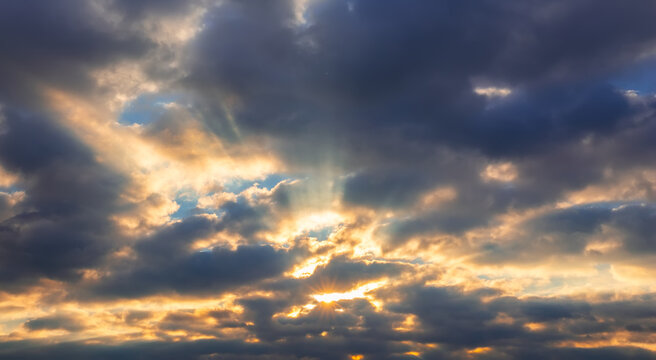 Powerful sky scene with sun rays shining through dramatic clouds. Atmospheric background with contrast light and shadow, perfect for nature, weather and spiritual concepts.