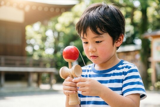 Close up of focused Japanese boy playing with traditional wooden Kendama toy