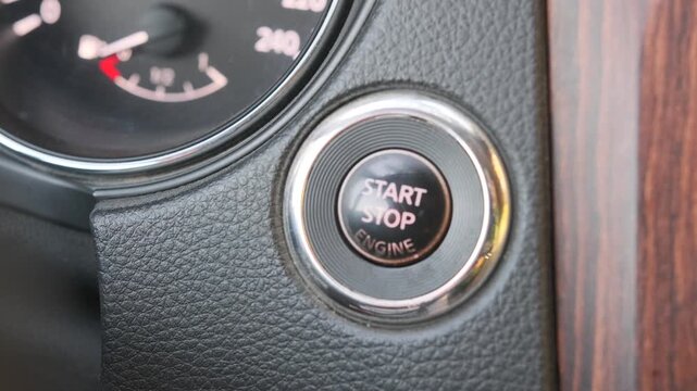 finger pressing start button close-up shot on car dashboard with ignition activation, driving scene showing engine start process and vehicle control system in modern interior environment