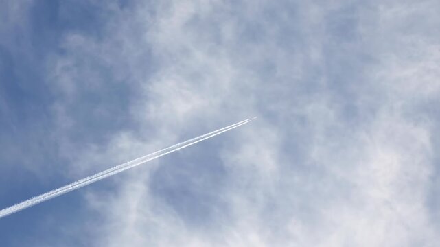 Commercial airline in the sky with vapour trails slow motion stock footage