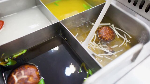 Ladle Scooping Shiitake and Enoki Mushrooms from Asian Shabu Shabu Hot Pot