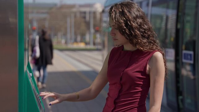 Young woman buying a public transport ticket