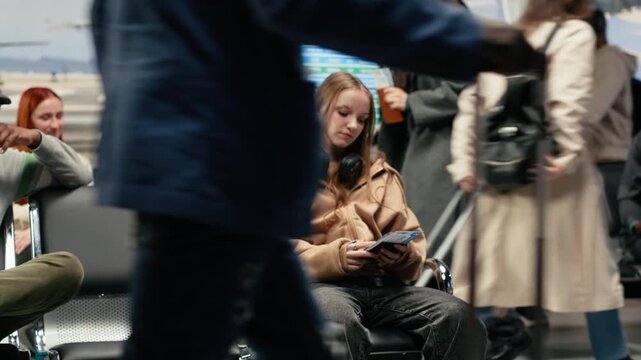 Young woman in airport lounge looking at airplane ticket, waiting for boarding gate checkin. Girl in modern aviation terminal holding passport document, doing journey back home, camera A
